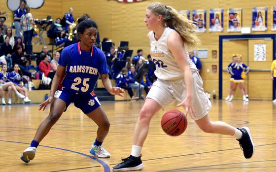 Wiesbaden's Gwen Icanberry dribbles as Ramstein's Brayln Jones defends during Tuesday evening's game at Wiesbaden High School in Wiesbaden, Germany. The Warriors won, 48-46.