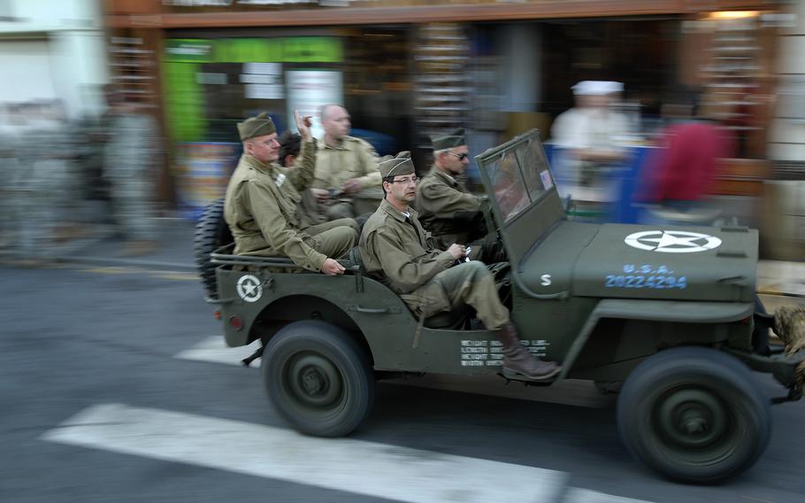 A jeep speeds by the Stop Bar, a popular hangout of active duty troops and re-enactors, June 4, 2009, in Saint-Mere-Eglise, France. Re-enactors from across Europe descended upon the French coastal towns for the 65th anniversary of D-Day.