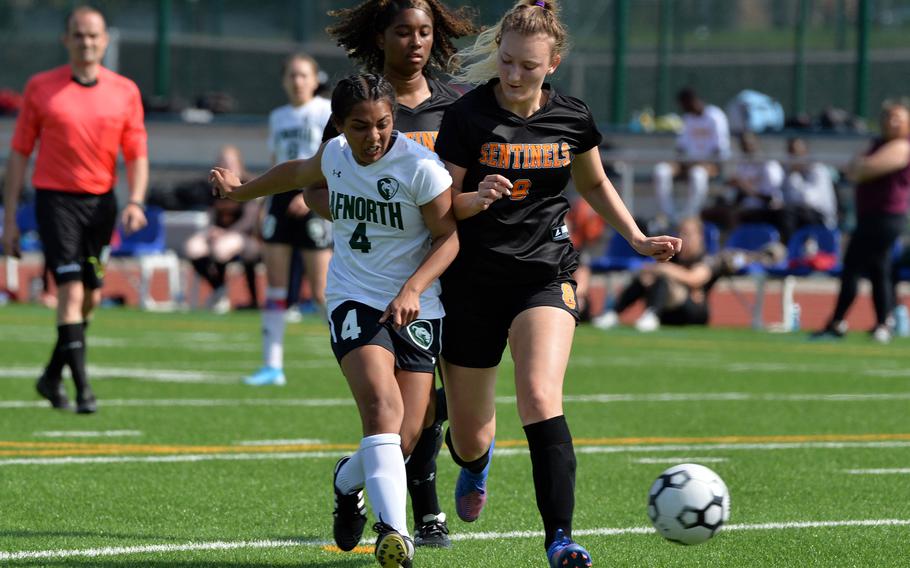 AFNORTH’s Selah Skariah gets past Spangdahlem’s Naomi Leggett and Kimberley Saylor, right, to score a goal in the Lions’ 3-0 win over the Sentinels in a girls Division III game on opening day of the DODEA-Europe soccer championships in Ramstein, Germany. 