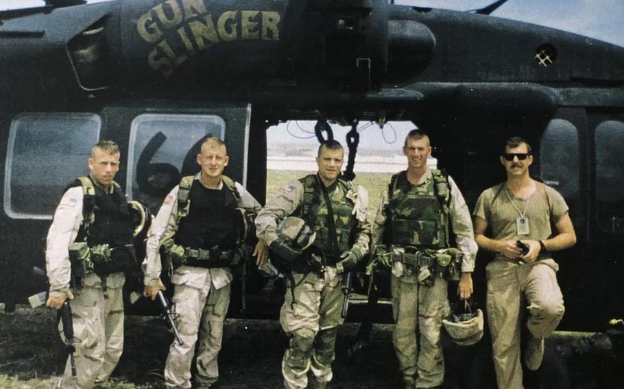 Retired Army Maj. Larry Moores (second from left) is shown with leaders in front of Gunslinger and pilot from TF 160.