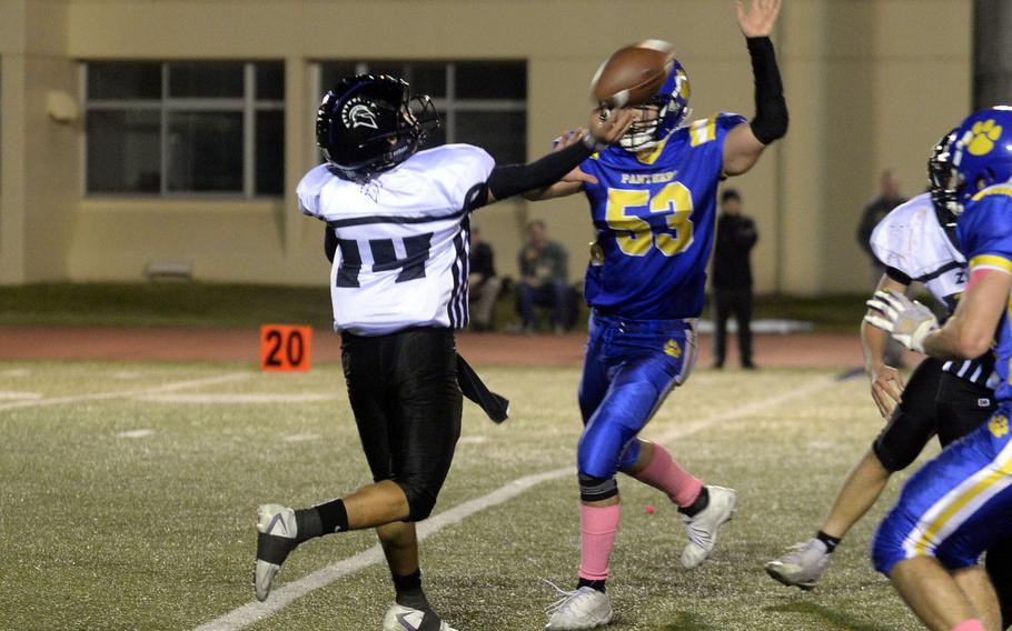 Zama quarterback Kai Kuroda gets the ball away just ahead of Yokota defender Kai Harbert.