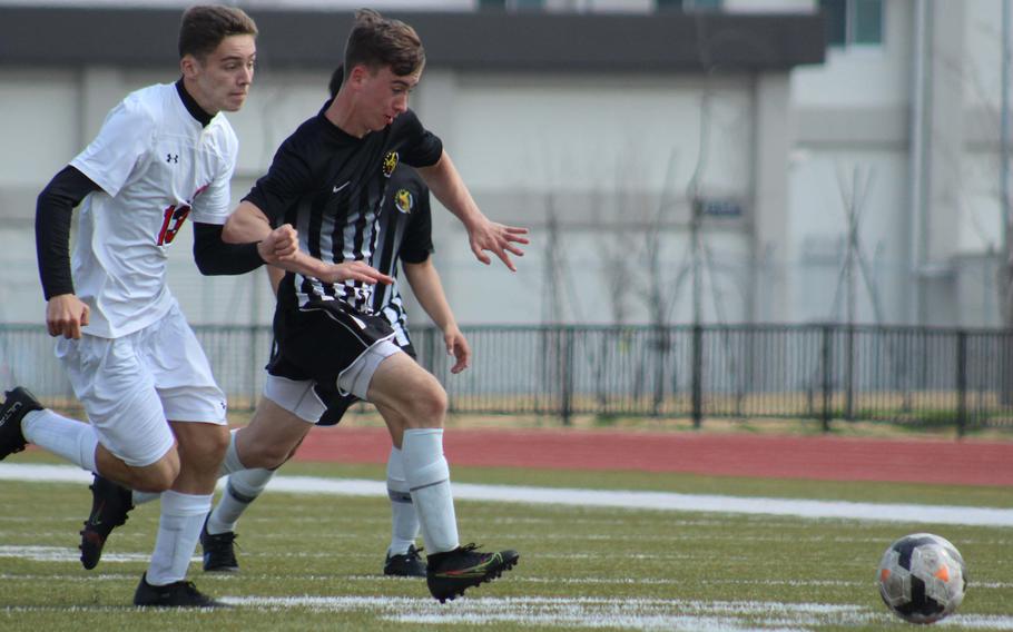 E.J. King's Kai Sperl and Matthew C. Perry's James Williams chase the ball during Saturday's DODEA-Japan soccere match. The Samurai won 4-2.