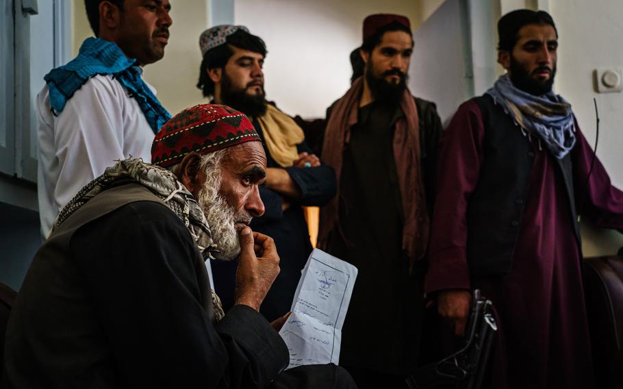 Several men sit in waiting to solve legal disputes in the ground-floor office of Abdul Qadeer Shahadatyar, a Taliban judge stationed in PD10, in Kabul, Afghanistan, Thursday, September 2, 2021. 