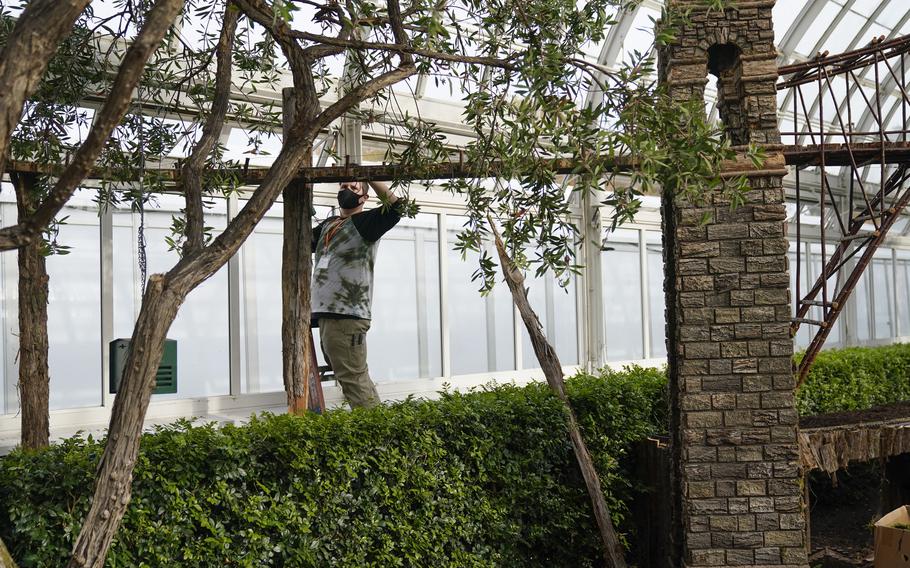 Kieran Beam works on tracks on a bridge as part of the preparations for the annual Holiday Train Show at the New York Botanical Garden in New York, Thursday, Nov. 11, 2021. The show, which opens to the public next weekend, features model trains running through and around New York landmarks, recreated in miniature with natural materials.