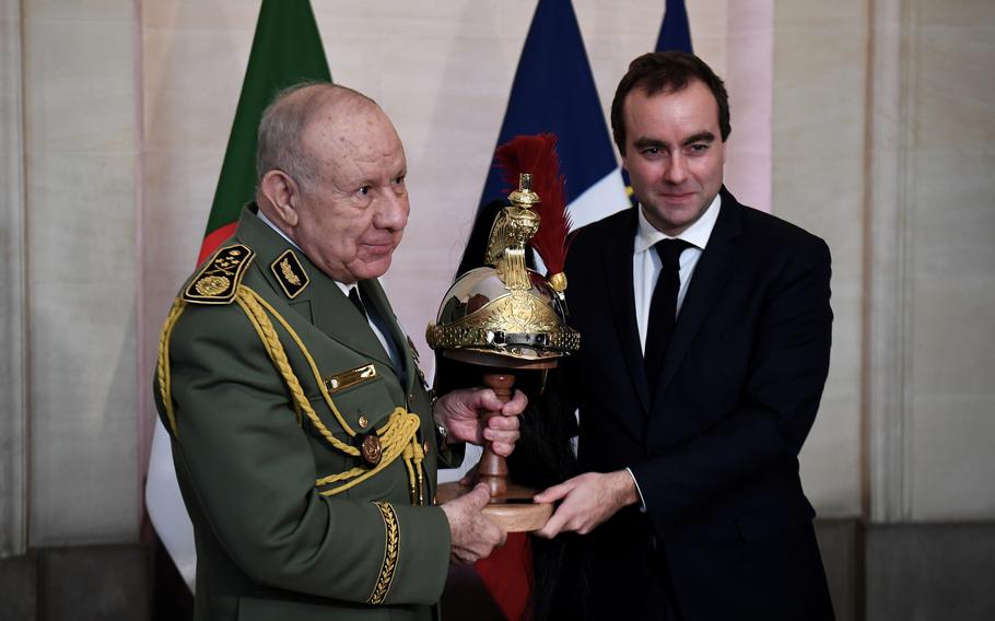 Algerian Army chief Gen. Said Chanegriha, left, receives a present from French Defense Minister Sebastien Lecornu, Tuesday, Jan. 24, 2023, in Paris. Algeria’s Defense Ministry said the visit was aimed at strengthening cooperation between the Algerian and French armies and would allow the two sides “to examine questions of common interest.”