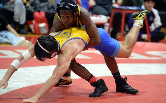 American School In Japan 133-pounder Cadell Lee, a former Virginia state champion, takes control of St. Mary's International's Nathaniel Twohig en route to an 11-0 technical-fall victory in the final.