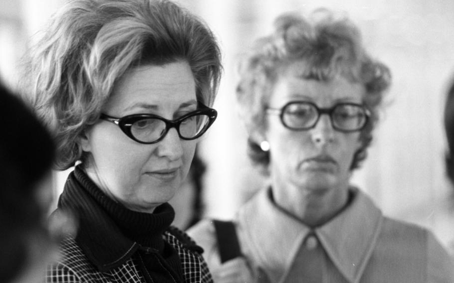 Two women with glasses look down