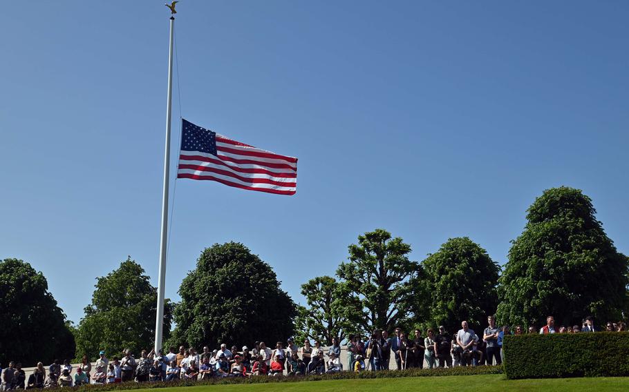 Spectators watch the Memorial Day ceremony at Lorraine American Cemetery in St. Avold, France, under an American flag flying at half-staff, May 28, 2023.