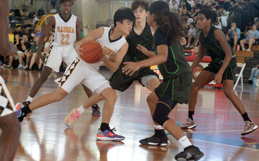 Kadena's Jaden Patsel drives against Kubasaki's Troy Harris and Maurice Brown during Sunday's semifinal, which the Panthers won 56-35.