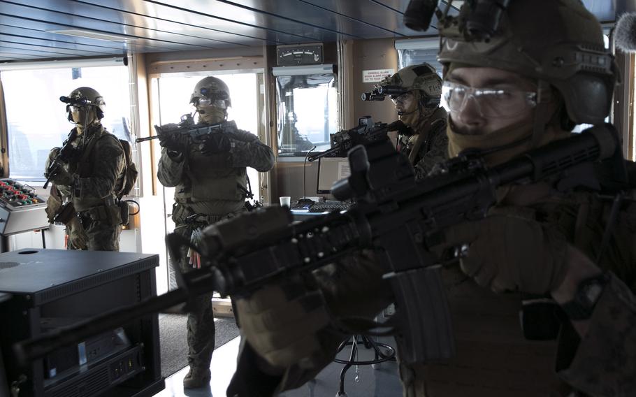 Members of the 31st Marine Expeditionary Unit enter the pilothouse of the USS Miguel Keith during visit, board, search and seizure training, part of the Noble Fusion exercise, in the East China Sea, Feb. 5, 2022. 