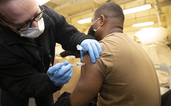 Hospital Corpsman 2nd Class Blaine Grandfield, from Merit, Texas, assigned to USS Gerald R. Ford’s (CVN 78) medical department, administers a COVID-19 booster shot to Air Traffic Controller 1st Class Owusu Poku, from Kunasi, Ghana, assigned to Ford’s operations department, during a COVID-19 booster shot exercise, Jan. 19, 2022. Ford is in port at Newport News Shipyard executing her Planned Incremental Availability (PIA), a six-month period of modernization, maintenance and repairs. (U.S. Navy photo by Mass Communication Specialist 3rd Class Zack Guth)