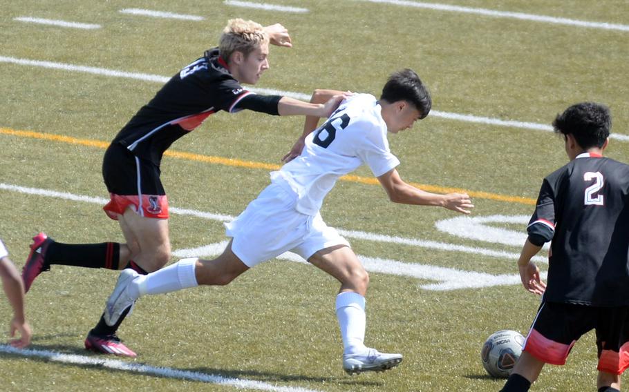 E.J. King's Kai Sperl and Kadena's Skylar Dluzeski chase the ball during Saturday's DODEA interdistrict boys soccer match. The Panthers won 1-0.