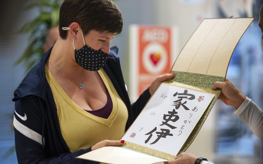 Kelley Hurley of the U.S. women’s Olympic team accepts gifts from the city of Iwakuni, Japan, Tuesday, July 13, 2021. Each athlete’s name was written in Japanese kanji calligraphy. 