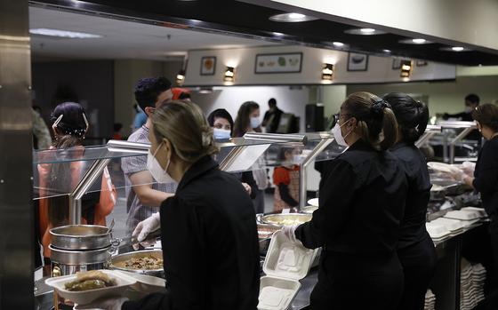Kitchen staff serve food to Afghan nationals in the dining room of the National Conference Center, which in recent months has been redesigned to temporarily house Afghan nationals, on Aug. 11, 2022, in Leesburg, Virginia. (Anna Moneymaker/Getty Images/TNS)