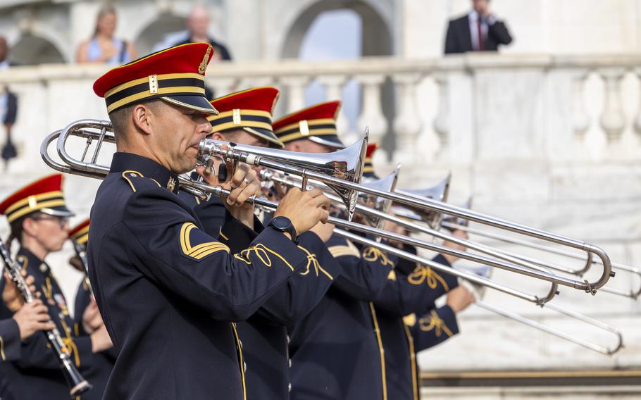 Members of an Army band play horn instruments.