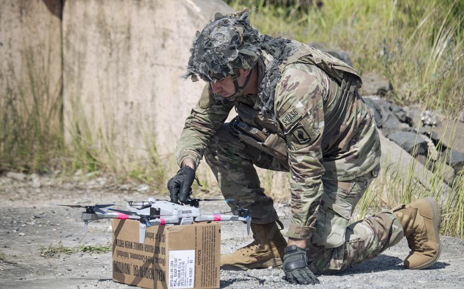 A U.S. soldier prepares to launch a Skydio X10D drone fixed with a dummy M67 munition.