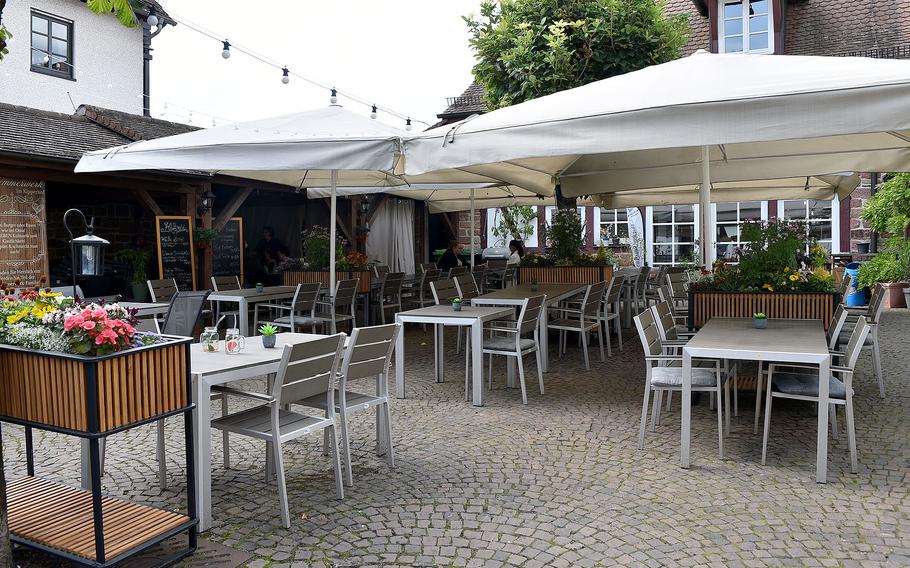 Tables sit empty at an outdoor seating area of a restuarant in Germany.