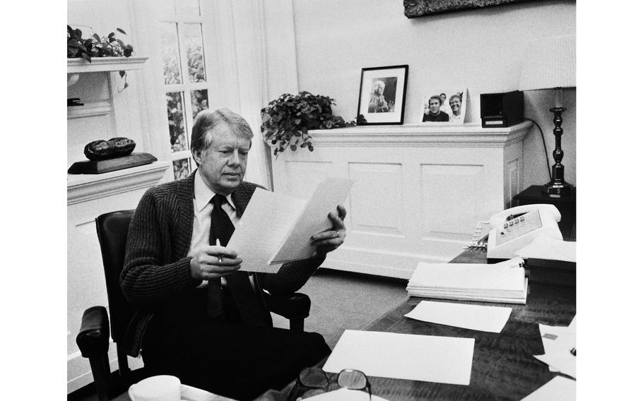 A photo taken in 1978 shows U.S. President Jimmy Carter phoning at his desk at the White House in Washington, D.C.