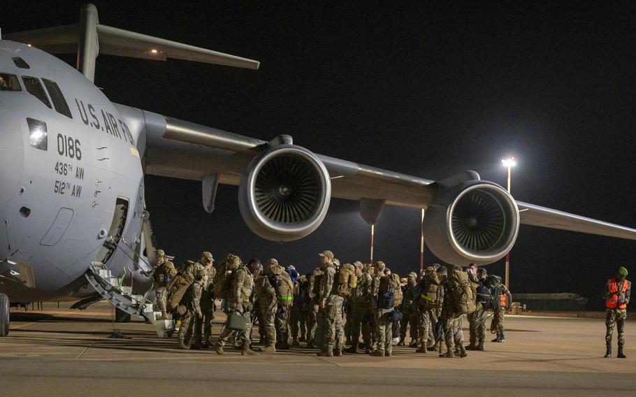 U.S. service members bid farewell to their colleagues as they board a U.S. Air Force C-17 aircraft departing Niamey, Niger. About 700 troops remain in Niger, where the military is withdrawing following a coup. The departure is expected to last through September.