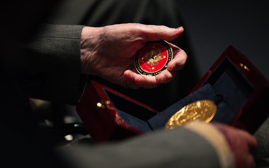 John Christman holds a Congressional Gold Medal and a coin from the Office of the Secretary of the Army before a special ceremony honoring World War II Ghost Army veterans on March 21, 2024. 