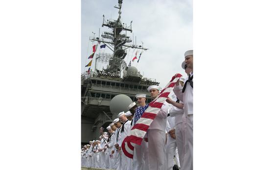 Yokosuka, Japan, May 6, 2003: Kitty Hawk sailors show the colors as the ship pulls into its home port of Yokosuka, Japan. The supercarrier returned to its home port after a 3 month deployment in support of Operation Iraqi Freedom. 

Read the story of Kitty Hawks homecoming from the Persian Gulf here. 
https://www.stripes.com/news/kitty-hawk-mccain-and-cowpens-are-back-home-1.5225

META TAGS: U.S. Navy; aircraft carrier; supercarrier; flag