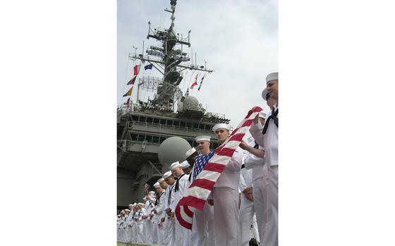 Yokosuka, Japan, May 6, 2003: Kitty Hawk sailors show the colors as the ship pulls into its home port of Yokosuka, Japan. The supercarrier returned to its home port after a 3 month deployment in support of Operation Iraqi Freedom. 

Read the story of Kitty Hawks homecoming from the Persian Gulf here. 
https://www.stripes.com/news/kitty-hawk-mccain-and-cowpens-are-back-home-1.5225

META TAGS: U.S. Navy; aircraft carrier; supercarrier; flag
