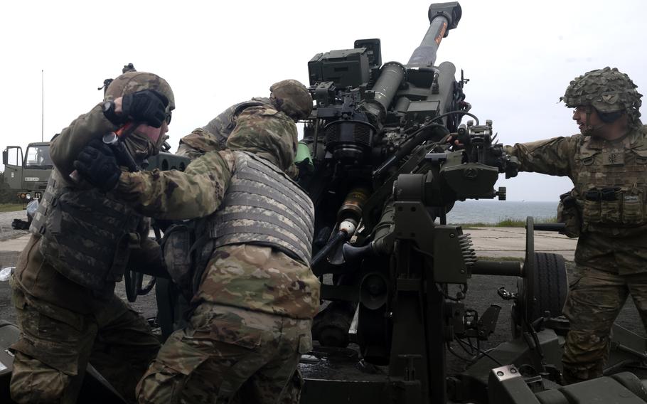 Soldiers get a Howitzer ready to fire.