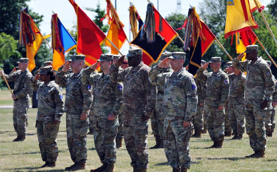 Soldiers on the parade field salute during the playing of the American and German national anthems at the U.S. Army Europe and Africa change of command ceremony in Wiesbaden, Germany, on June 28, 2022.