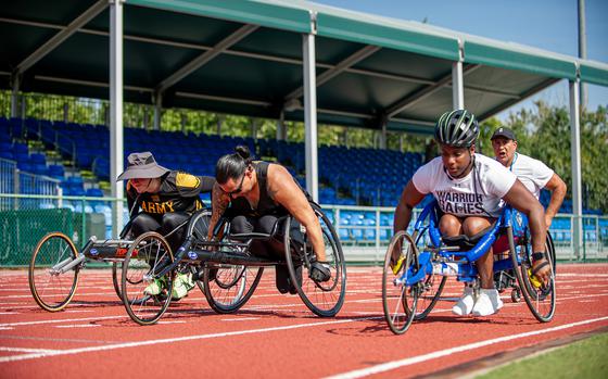 Army Maj. Victoria Camire, left, retired Staff Sgt. Joel Rodriguez, center, and Cpl. Tiffanie Johnson practice wheelchair racing for the Warrior Games at the ESPN Wide World of Sports Complex in Orlando, Fla., Aug. 19, 2022. 