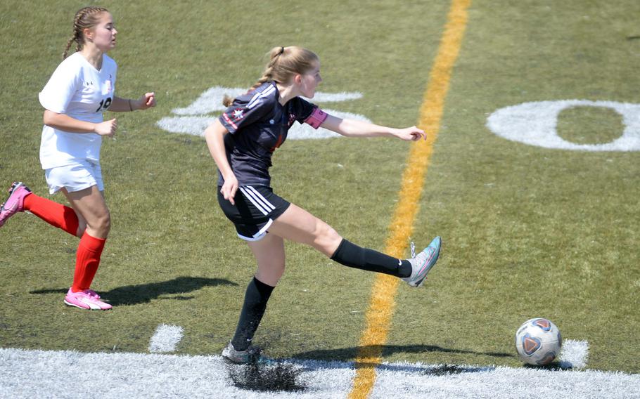 Nile C. Kinnick's Bree Withers boots the ball ahead of E.J. King's Liana Blake during Saturday's DODEA-Japan girls soccer match. The Red Devils won 2-0.