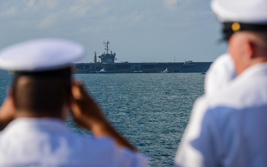 Sailors aboard the USS Bataan, an amphibious assault ship, look out at the USS Harry S. Truman aircraft carrier as the Bataan pulls into the port of Miami for Fleet Week on Sunday, May 5, 2024.