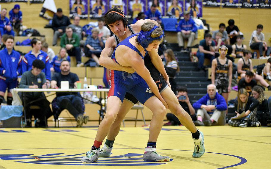Spangdahlem's Troy Truscott and Ramstein's Kilun Engelbrecht grapple during the 126-pound final at the Warrior Wraggle on Jan. 13, 2024, at Wiesbaden High School in Wiesbaden, Germany.