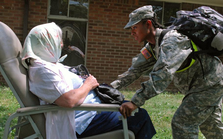 Spc. Stephanie Williams, a combat medic assigned to the 690th Medical Company (Ground Ambulance) from Fort Benning, Ga., attempts to calm a displaced civilian suffering from dementia during a Vibrant Response 13 field training exercise at the Muscatatuck Urban Training Center, Ind., July 26, 2012.