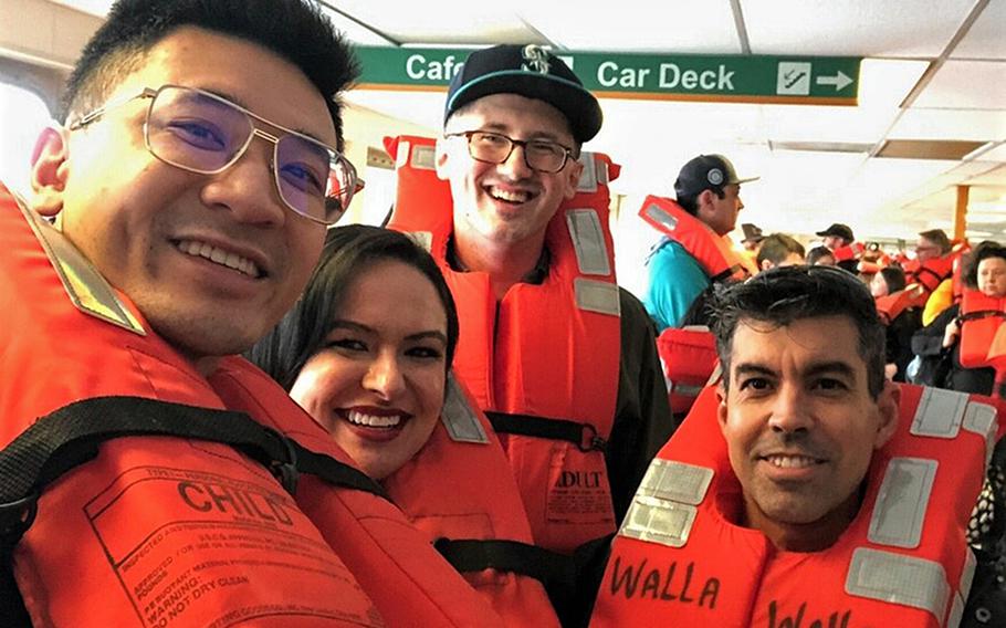 From left, Lt. j.g. Randy Le, Lt. Holly Sapien, Petty Officer 3rd Class John Landis and Petty Officer 1st Class Michael Sapien take a selfie aboard the MV Walla Walla after it ran aground on Bainbridge Island, Wash., April 15, 2023, due to power loss. Holly Sapien took the lead in stabilizing a man who suffered an epileptic seizure aboard the vessel.
