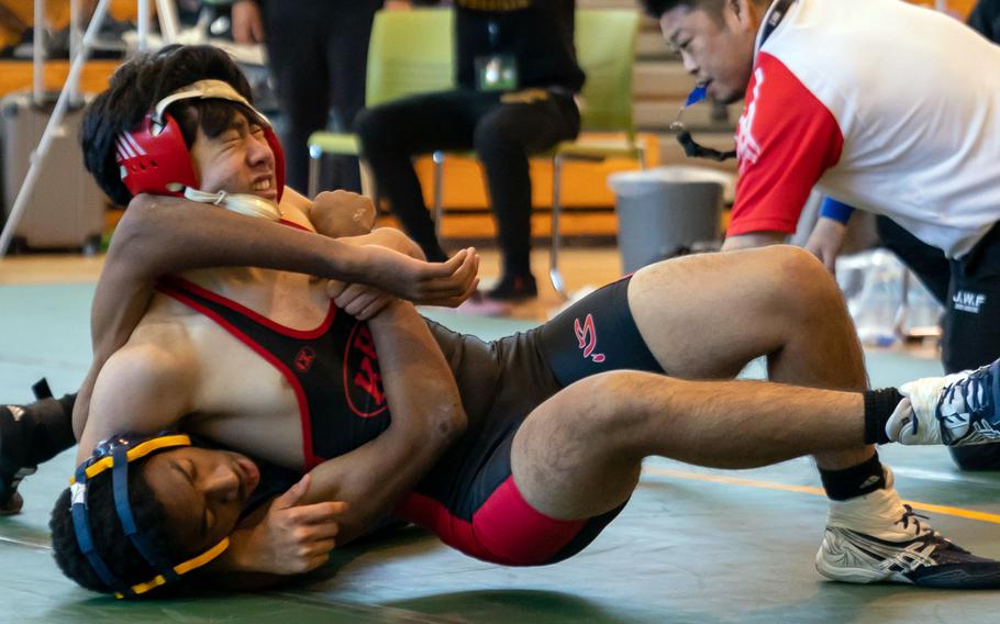 Nile C. Kinnick's Julio Ono locks in a head-and-arm hold on Yokota's Jerald Roddy at 148 pounds during Saturday's DODEA-Japan wrestling tri-meet. Ono won by pin and the Red Devils took the dual meet 49-8.