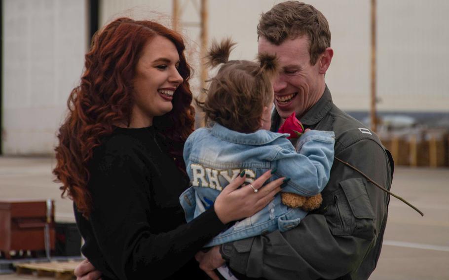 An aviator assigned to Strike Fighter Squadron (VFA) 213, “Blacklions,” reunites with his family during a homecoming celebration onboard Naval Air Station Oceana, Jan. 15, 2024.