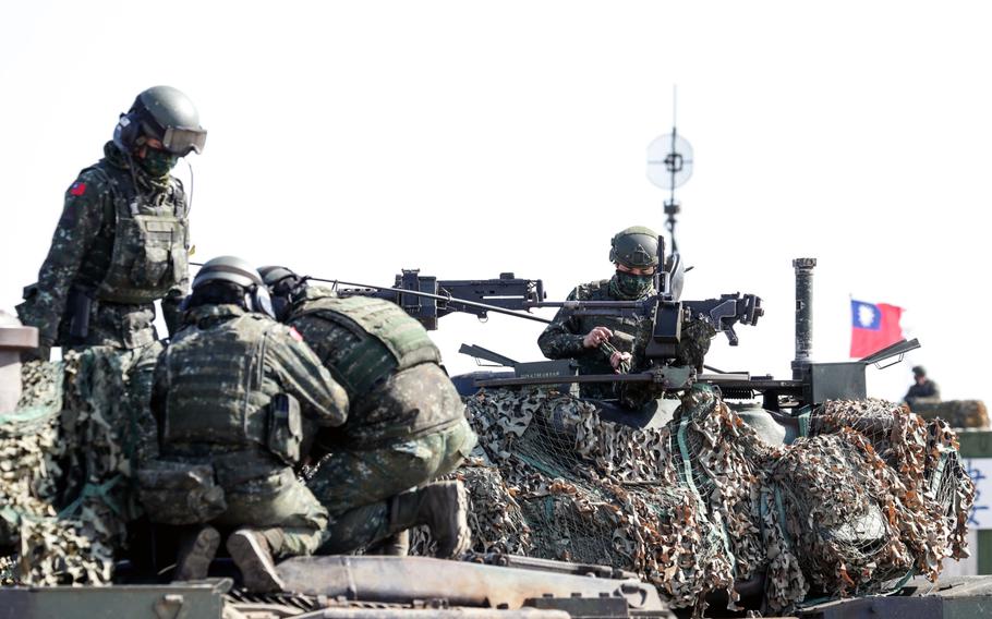 Members of Taiwan’s armed forces wearing protective masks stand atop military vehicles during a military exercise in Hukou, Hsinchu County, Taiwan, on Jan. 19, 2021.
