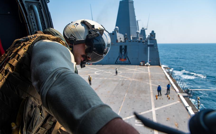 A sailor loos out from aboard a ship.