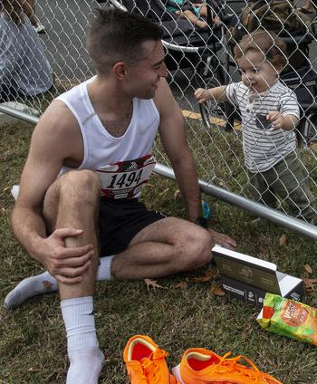 A runner talks to his biggest fan on the other side of the fence after the 48th Marine Corps Marathon on Sunday, Oct. 29, 2023, in Arlington, Va.