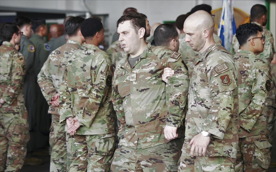 An overheated airman is escorted out of formation during the 18th Wing change-of-command ceremony at Kadena Air Base, Okinawa, Thursday, July 6, 2023.