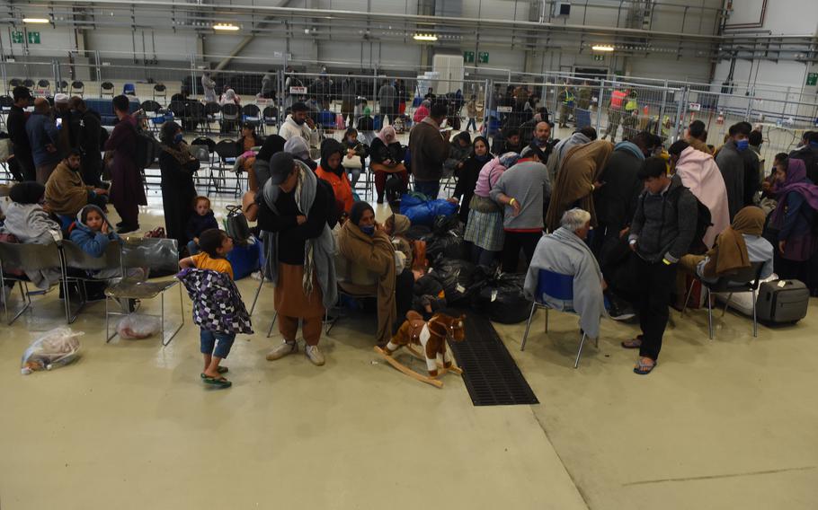 Evacuees from Afghanistan wait to board a plane inside a makeshift passenger terminal at Ramstein Air Base, Germany, on Thursday, Aug. 26, 2021. More than 3,500 evacuees have left Ramstein for a new life in the United States but thousands more are inbound. Ramstein was expecting about 10,000 incoming evacuees overnight Thursday.