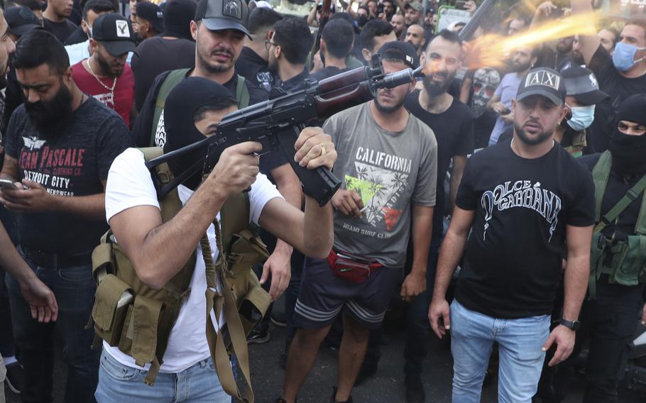 Supporters of the Shiite Amal group fire weapons in the air during the funeral processions of Hassan Jamil Nehmeh, who was killed during yesterday clashes, in the southern Beirut suburb of Dahiyeh, Lebanon, Friday, Oct. 15, 2021. Dozens of gunmen opened fire in the air Friday south of Beirut during the funeral of persons killed in hours of gun battles between heavily armed gunmen the day before that left several people dead and terrorized the residents of Beirut.