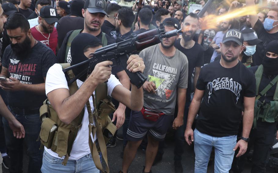 Supporters of the Shiite Amal group fire weapons in the air during the funeral processions of Hassan Jamil Nehmeh, who was killed during yesterday clashes, in the southern Beirut suburb of Dahiyeh, Lebanon, Friday, Oct. 15, 2021. Dozens of gunmen opened fire in the air Friday south of Beirut during the funeral of persons killed in hours of gun battles between heavily armed gunmen the day before that left several people dead and terrorized the residents of Beirut. 