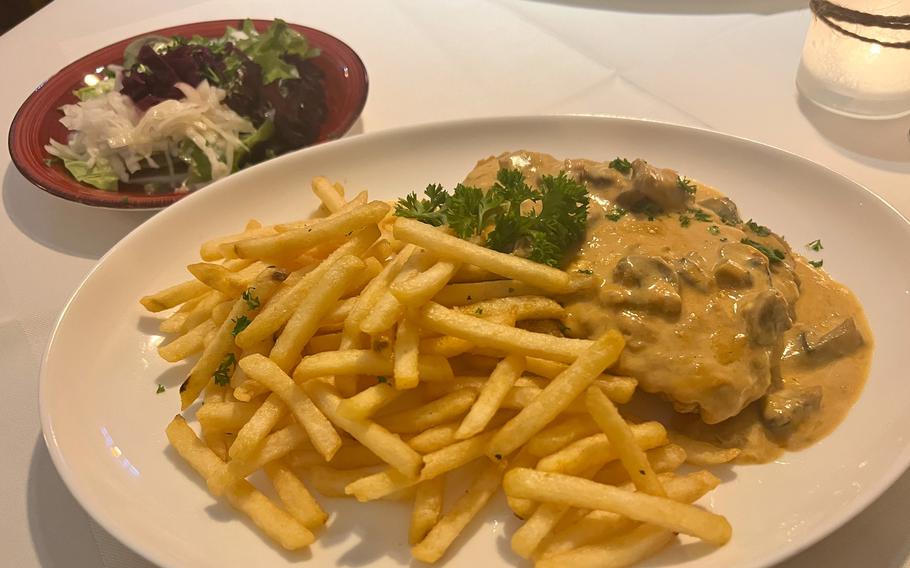 A vegan rendition of schnitzel with creamy mushroom sauce at Zur Pfaffschenke restaurant in Kaiserslautern, Germany. Instead of pork, the fried steak is made from a large piece of vegan soy product with a bread-like texture. 