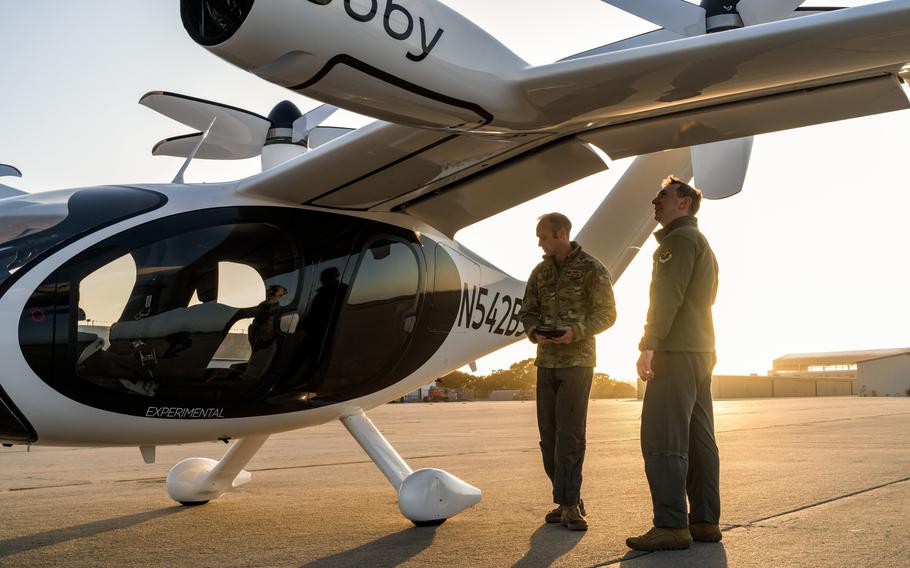 Two U.S. Air Force pilots inspect Joby’s vertical takeoff and landing aircraft in April 2023. The aircraft soon will be delivered to Edwards Air Force Base in California.