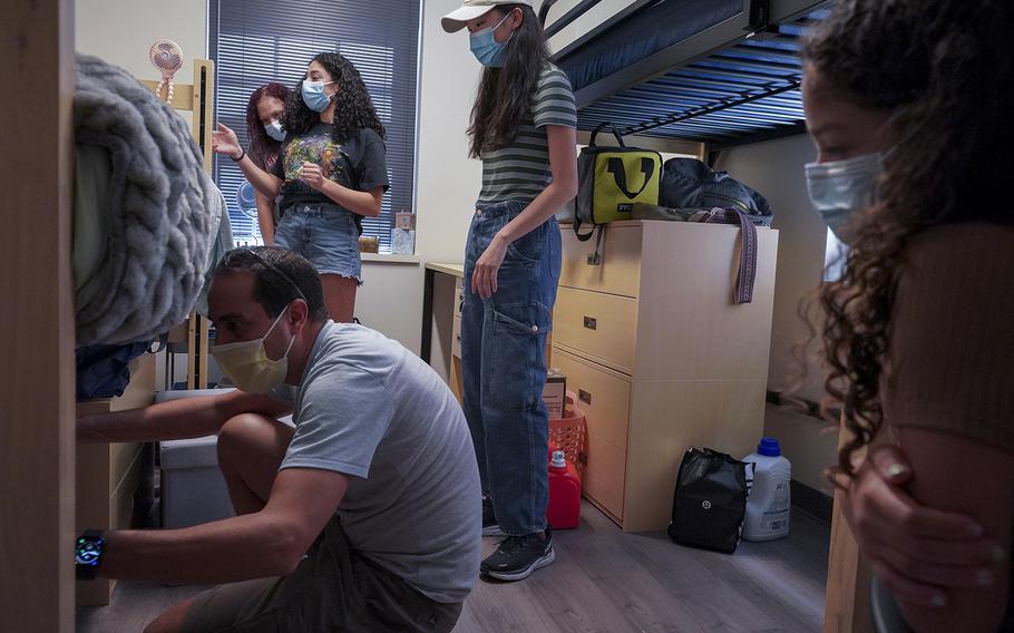 New roommates Julie Marwan, rear, and Lily Huang, center, get help from Marwan’s parents, Rony Marwan, foreground, Dalia El-Prince, rear left, and Lila Marwan, 9, as they move into their room at George Washington University. 