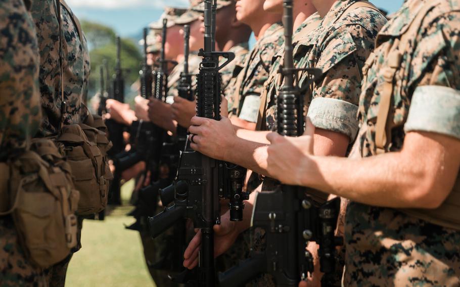 Marines present arms during a ceremony at Marine Corps Base Hawaii, on March 3, 2022. The Marine Corps’ proposed budget for fiscal 2023 released Monday, March 28, 2022, would shrink the active-duty force by about 1,500.
