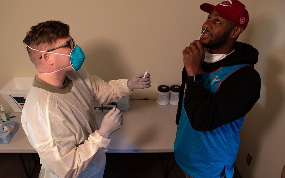 An airman demonstrates how to properly swab a nose for a COVID-19 antigen test earlier this year at Osan Air Base, South Korea. 