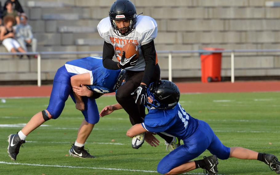 Spangdahlem’s MJ Brown jumps through Brussels defenders Sawyer Ter Horst, left, and Wilson Stewart for a gain in the DODEA-Europe Division III football final in Kaiserslautern, Germany, Oct. 29, 2022. Brussels captured the crown with a 64-48 win.