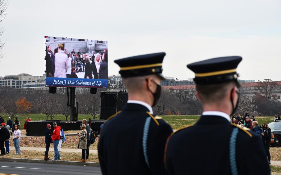 Two service members wait to meet the funeral procession for Sen. Bob Dole on Friday, Dec. 10, 2021. A public remembrance was held for Dole at the National World War II Memorial.  